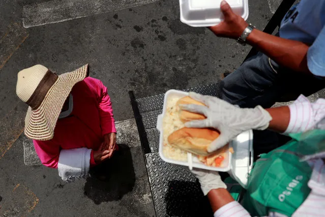 A woman waits to receive donated food from a food truck implemented by the government to provide daily free meals for people in need amid the continuous coronavirus disease (COVID-19) outbreak in Mexico City, Mexico, Mexico on June 19, 2020. (Photo by Carlos Jasso/Reuters)