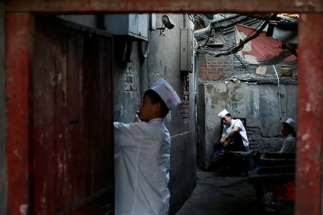 Kitchen staff sit in a back alley behind a restaurant in Beijing, China, August 25, 2016. (Photo by Thomas Peter/Reuters)