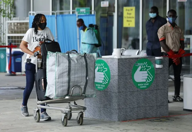 A passenger wearing a face mask pushes a trolley outside the Nnamdi Azikiwe International Airport, on its re-opening day for domestic flight operations, following the coronavirus disease (COVID-19) outbreak, in Abuja, Nigeria on July 8, 2020. (Photo by Afolabi Sotunde/Reuters)