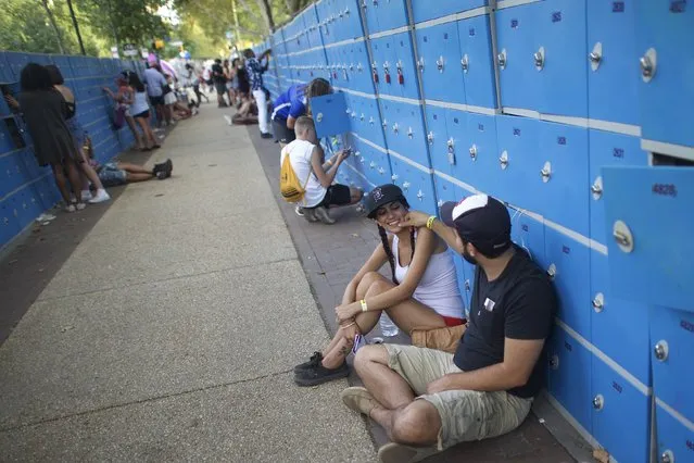 Kaline Hamadi and Rami Zein (R) huddle by the phone charging lockers during the Made in America music festival in Philadelphia, Pennsylvania September 5, 2015. (Photo by Mark Makela/Reuters)