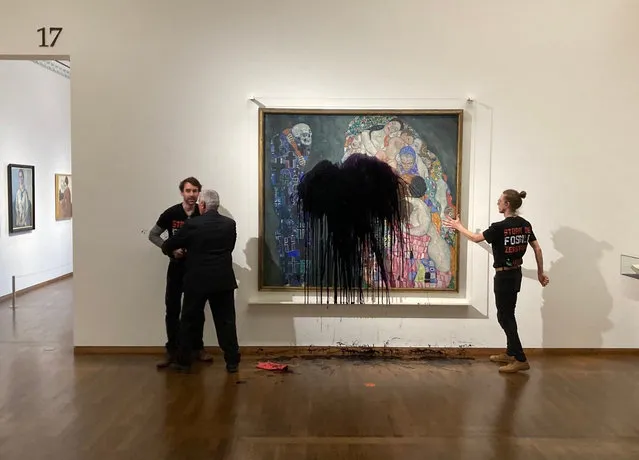 This handout picture released on November 15, 2022 by the “Last Generation” shows a climate activist of the “Last Generation” group being overpowerd whereas another one has glued himself to the painting “Death and Life” by Austrian artist Gustav Klimt after pouring black liquid over the art work at the Leopold Museum in Vienna, Austria. A spokesman of the museum said that restorers were working to determine whether the painting protected by glass has been damaged. Admission to the Leopold Museum was free on Tuesday, November 15, as part of a day sponsored by the Austrian oil and gas group OMV. (Photo by Handout/Letzte Generation Österreich via AFP Photo)