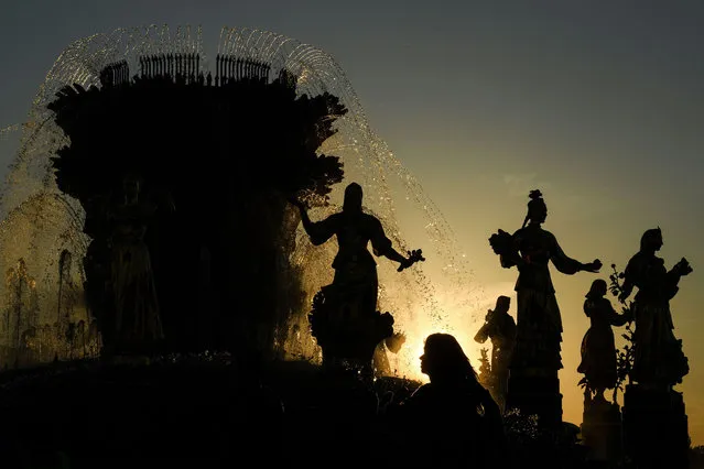 A woman walks during the sunset in front of the famous Druzhba Narodov (Friendship of nations) fountain in the All-Russia Exhibition Centre (VDNKh), a trade show and amusement park in Moscow on June 14, 2020, amid the outbreak of COVID-19, caused by the novel coronavirus. Russia, the country with the world's third-largest coronavirus outbreak, passed the symbolic milestone of 500,000 confirmed cases last week, after the capital lifted tight lockdown restrictions. (Photo by Kirill Kudryavtsev/AFP Photo)