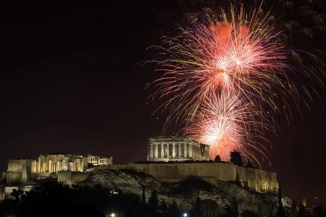 Fireworks explode over the ancient Parthenon temple at the Acropolis hill during New Year celebrations in Athens, Greece, Sunday, January 1, 2023. (Photo by Yorgos Karahalis/AP Photo)