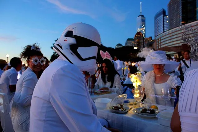 A man wears a Star Wars Helmet as he attends the “Diner en Blanc” (Dinner in White) in Battery park New York on Septembre 15, 2016. The “Diner en Blanc” is a chic secret pop-up style picnic phenomenon originally started in France. (Photo by Kena Betancur/AFP Photo)