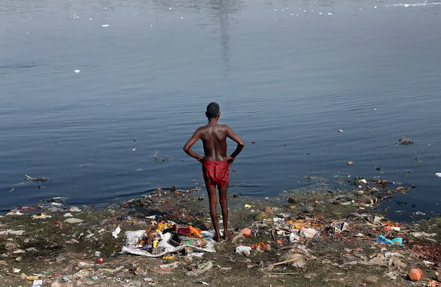 An Indian coin diver stands at the bank of the polluted Yamuna river in New Delhi, India, 09 October 2017. The divers make their living by collecting coins and re-selling them. There is a tradition in India of throwing coins into a river for good luck at the start of a journey. The Yamuna River, like all other holy rivers in India, has been massively polluted for decades now. The river that originates in a glacier in the pristine and unpolluted Himalayas, and flows through Haryana, Delhi and Uttar Pradesh before merging with the Ganges River in Allahabad, once used to be the lifeline of the Indian capital. Currently, it is no more than a large, open sewer that is choking with industrial and domestic discharge that includes plastic, flowers and debris and has virtually no aquatic life. (Photo by Harish Tyagi/EPA/EFE)