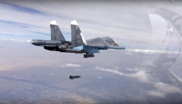 In this photo made from the footage taken from Russian Defense Ministry official web site on Friday, October 9, 2015, a bomb is released from Russian Su-34 strike fighter in Syria. Activists report intense fighting between insurgents and Syrian troops in the country's center amid new territorial gains for the government, backed by Russian airstrikes. (Photo by Russian Defense Ministry Press Service via AP Photo)