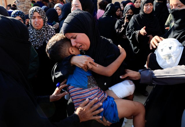 A mourner reacts holding a child during the funeral of Palestinians, who, according to Gaza's health ministry, were killed in an overnight Israeli strike on a tent, at Nasser Hospital in Khan Younis, southern Gaza Strip on July 3, 2025. (Photo by Hatem Khaled/Reuters)