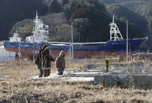 A family visits the place where their house was swept away by the tsunami in Kesennuma, Miyagi Prefecture, Japan, on Sunday. (Photo by Shizuo Kambayashi/AP Photo)