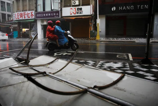 A motorcyclist rides past advertisement banners damaged by Typhoon Megi in Hualien, eastern Taiwan September 27, 2016. (Photo by Tyrone Siu/Reuters)