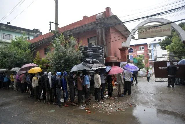 Nepalese people and Indian Migrant workers along with an umbrella lining for PCR test outside at the Sukraraj Tropical &amp; Infectious Disease Hospital, Teku, Kathmandu, Nepal on  September 24, 2020. (Photo by Narayan Maharjan/NurPhoto via Getty Images)