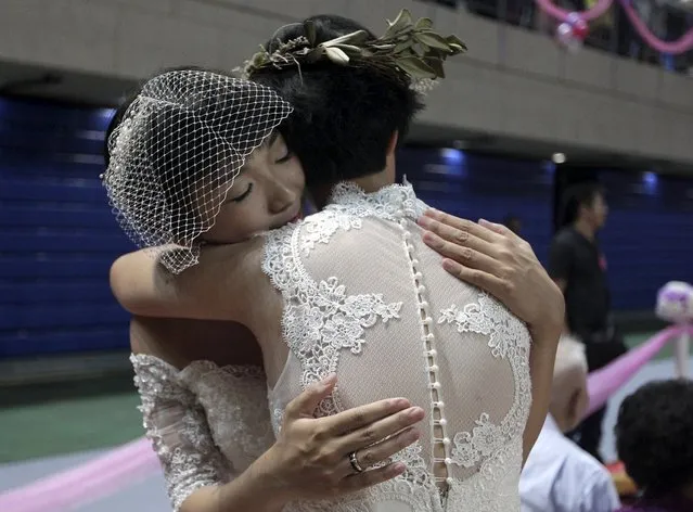 A same-s*x couple hugs during a mass wedding ceremony in Taipei, Taiwan, October 24, 2015. (Photo by Pichi Chuang/Reuters)