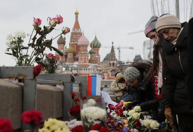 People visit the site of the assassination of Russian opposition leader Boris Nemtsov as they mark the third anniversary of Nemtsov's death, with the St. Basil's Cathedral seen in the background, in central Moscow, Russia February 25, 2018. (Photo by Maxim Shemetov/Reuters)
