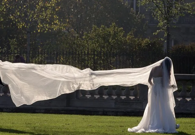 A Chinese future bride poses for photos on the Invalides square in the autumn light in Paris, France, October 26, 2015. (Photo by Philippe Wojazer/Reuters)