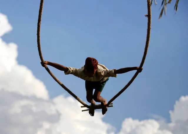 A boy plays on a traditional swing during Dashain, the biggest religious festival for Hindus in Nepal, in Kathmandu, Nepal October 4, 2016. (Photo by Navesh Chitrakar/Reuters)