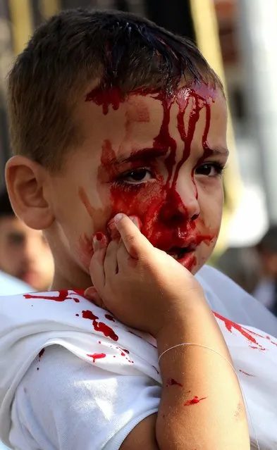 A Lebanese Shiite Muslim child has blood running down his face during a flagellation ceremony marking Ashura in the southern Lebanese city of Nabatieh on October 12, 2016. (Photo by Mohammed Sawaf/AFP Photo)