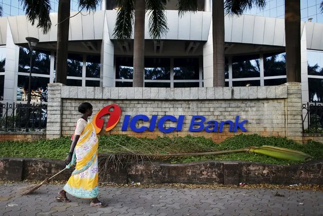 A municipal worker walks past a logo of ICICI Bank at its headquarters in Mumbai in this October 25, 2013 file photo. (Photo by Danish Siddiqui/Reuters)