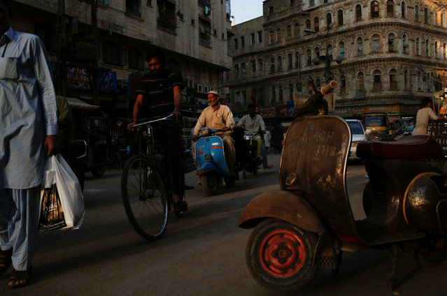 A man rides a Vespa scooter on a busy street, in a low-income neighbourhood in Karachi, Pakistan on March 6, 2018. (Photo by Akhtar Soomro/Reuters)