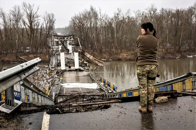 A Ukrainian Army soldier surveys a blown bridge in the Siverskiy-Donets river on February 27, 2023 in Bogorodychne, Ukraine. Last February, Russia's military invaded Ukraine from three sides and launched airstrikes across the country. Since then, Moscow has withdrawn from north and central parts of Ukraine, focusing its assault on the eastern Donbas region, where it had supported a separatist movement since 2014. (Photo by John Moore/Getty Images)
