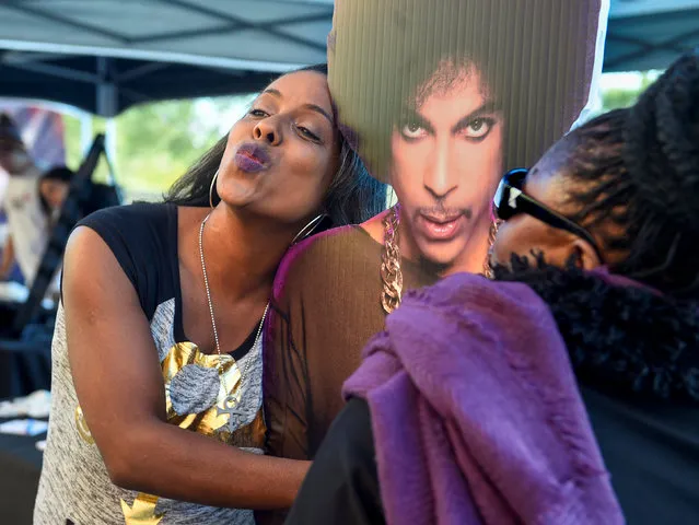 Trena lawson of Hermosa Beach CA, poses next to a life size cut-out of Prince as fans gather for an all-star concert tribute planned for in memory of Prince, six months after the influential pop star died, in St. Paul, Minnesota, U.S., October 13, 2016. (Photo by Craig Lassig/Reuters)