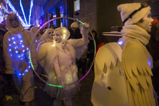 People dressed in illuminated angel costumes parade to mark Christmas Day in central Moscow, Russia, on Thursday, December 25, 2014. (Photo by Pavel Golovkin/AP Photo)