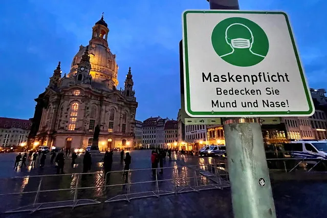 A sign for the mandatory use of protective mask is pictured in front of Frauenkirche (Church of Our Lady) after a demonstration of coronavirus skeptics was officially cancelled, as the spread of the coronavirus disease (COVID-19) continues in Dresden, Germany, December 12, 2020. (Photo by Hannibal Hanschke/Reuters)