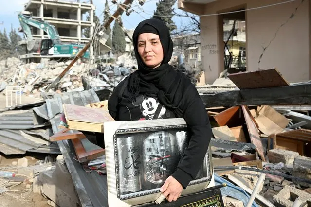 Earthquake survivor Fatma Cantali rescues the Holy Quran and frame of Quran's verses from her wrecked house's debris after 7.7 and 7.6 magnitude earthquakes hit in Hatay, Turkiye, on March 21, 2023. (Photo by Mehmet Kaman/Anadolu Agency via Getty Images)