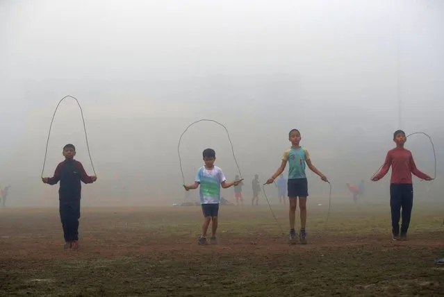 Indian boys practice in a field surrounded by dense fog on a cold morning in Gauhati, northeastern Assam state, India, Wednesday, December 16, 2020. (Photo by Anupam Nath/AP Photo)