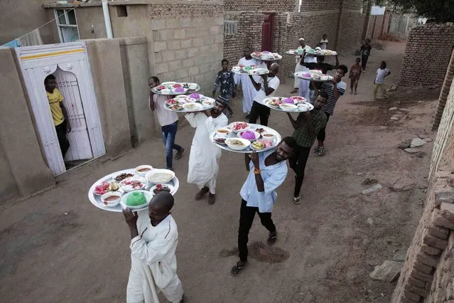 Men bring food to break the fast during the holy month of Ramadan in Khartoum, Sudan, Friday, April 7, 2023 .(Photo by Marwan Ali/AP Photo)