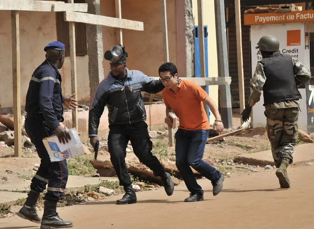 Malian security forces evacuate a man from an area surrounding the Radisson Blu hotel in Bamako on November 20, 2015. Gunmen went on a shooting rampage at the luxury hotel in Mali's capital Bamako, seizing 170 guests and staff in an ongoing hostage-taking that has left at least three people dead. (Photo by Habibou Kouyate/AFP Photo)