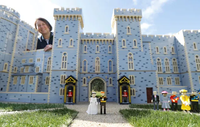 Head model maker, Paula Laughton poses for a photograph with a LEGO Windsor Castle replete with royal wedding between Britain's Prince Harry and Meghan Markle, in Windsor, Britain May 10, 2018. (Photo by Peter Nicholls/Reuters)