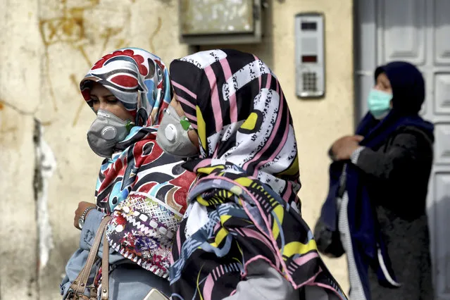 People wear masks to help guard against the Coronavirus in downtown Tehran, Iran, Sunday, February 23, 2020. On Sunday Iran's health ministry raised the death toll from the new virus to 8 people in the country, amid concerns that clusters there, as well as in Italy and South Korea, could signal a serious new stage in its global spread. (Photo by Ebrahim Noroozi/AP Photo)