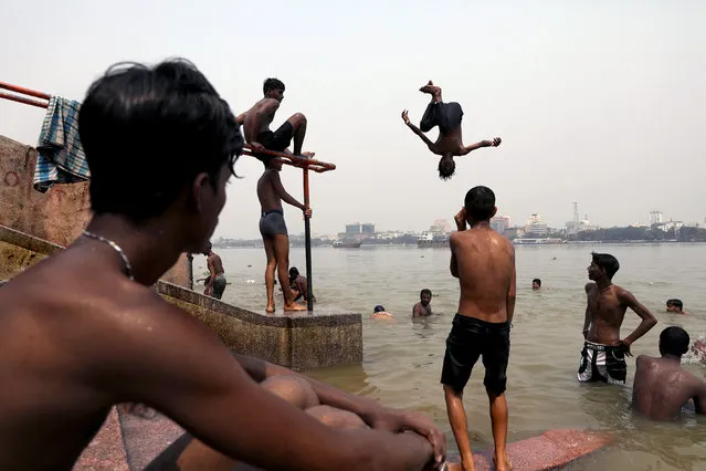 Indian boys jump into the river Ganga as they cool off during a hot afternoon in Kolkata, India, 18 April 2023. Bengal's maximum temperature reaches 41 degree celcious this summer. The summer, or pre-monsoon season, occurs from March to July in eastern India, with the highest daytime temperatures ranging from 38 to 45 degrees Celsius. (Photo by Piyal Adhikary/EPA/EFE/Rex Features/Shutterstock)