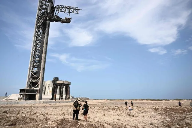 Members of the public walk through a debris field at the launch pad on April 22, 2023, after the SpaceX Starship lifted off on April 20 for a flight test from Starbase in Boca Chica, Texas. The rocket successfully blasted and the Starship capsule had been scheduled to separate from the first-stage rocket booster three minutes into the flight but separation failed to occur and the rocket blew up. (Photo by Patrick T. Fallon/AFP Photo)