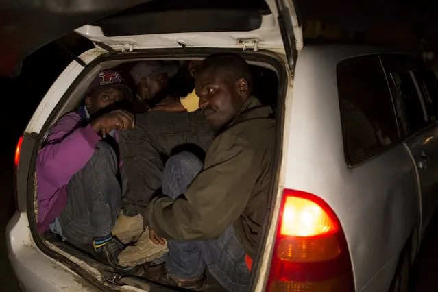 A group of men are crammed into the boot of an unmarked police vehicle after being detained for questioning in Korogocho during a night patrol in Nairobi, Kenya, October 30, 2015. (Photo by Siegfried Modola/Reuters)