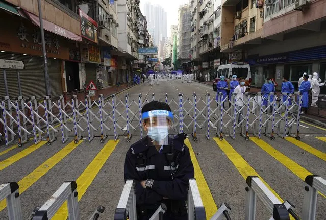 A police officer stands guard at the Yau Ma Tei area, in Hong Kong, Saturday, January 23, 2021. Thousands of Hong Kong residents were locked down Saturday in an unprecedented move to contain a worsening outbreak in the city, authorities said. (Photo by Vincent Yu/AP Photo)
