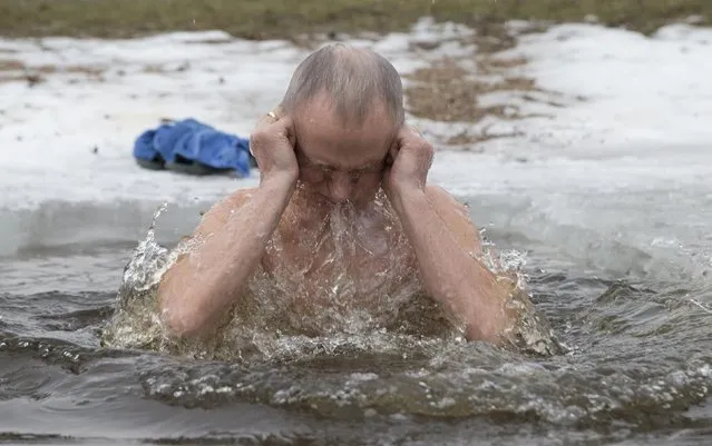A man reacts after dipping himself into a icy lake in Minsk, January 18, 2015. (Photo by Vasily Fedosenko/Reuters)