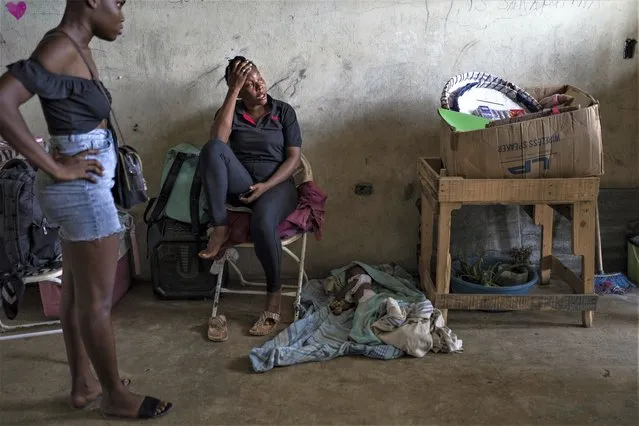 Elise Messadien cries as she sits next to the body of her 1-year-old goddaughter, who is believed to have died of dehydration, at a shelter for people displaced by gang violence, in Port-au-Prince, Haiti, Tuesday, May 30, 2023. (Photo by Ariana Cubillos/AP Photo)