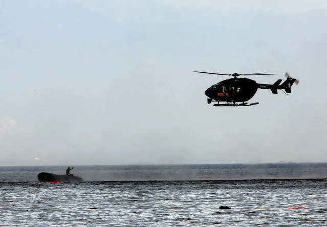 A Frontex helicopter stops a dinghy with a suspected smuggler off the Greek island of Lesbos September 24, 2015. (Photo by Yannis Behrakis/Reuters)