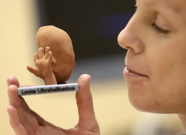 Mother-to-be Maarja Lants looks at a three-dimensional (3D) print model of her unborn baby in Tallinn January 28, 2015. (Photo by Ints Kalnins/Reuters)