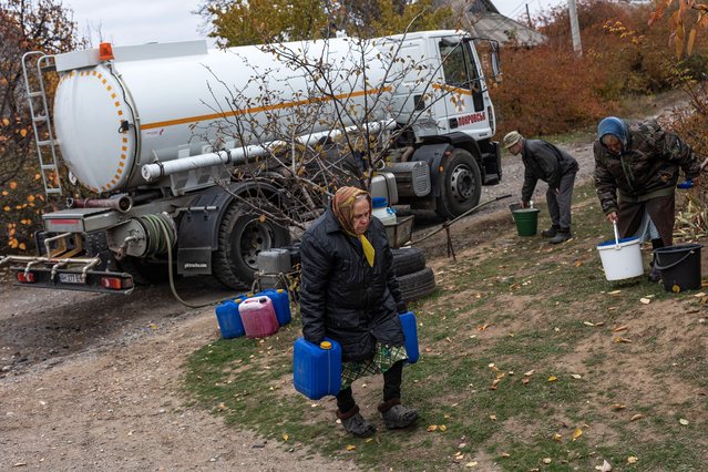 A woman carries water in canisters as Ukrainian emergency services deliver water to neighborhoods in Kostiantynivka that have lost their water supply due to Russian shelling of the city, in Kostiantynivka, Ukraine on November 13, 2024. (Photo by Diego Herrera Carcedo/Anadolu via Getty Images)