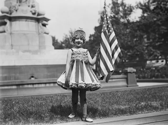 A young girl dressed in a liberty costume holds an American flag suring Fourth of July celebration, in Washington D.C., 1916. (Photo by Harris & Ewing, GHI/Universal History Archive via Getty Images)