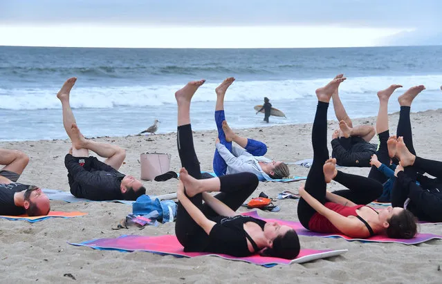 Yoga instructor Vee Gomez leads a beach yoga class on an overcast evening at Santa Monica beach in Santa Monica, California on June 21, 2018, to celebrate International Yoga Day, which is also the summer solstice. (Photo by Frederic J. Brown/AFP Photo)