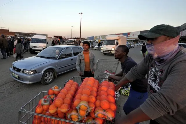 A street vendor selling oranges at a taxi rank in Welkom, South Africa, Friday, June 23, 2023. At least 31 people were believed to have died in a gas explosion in a disused mine shaft in the city of Welkom that happened last month but was only now coming to light, authorities said Friday. (Photo by Themba Hadebe/AP Photo)
