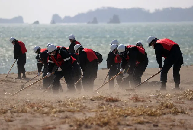 Police officers search for remains of those who went missing in the tsunami generated by the Great East Japan Earthquake 10 years ago, at the seashore in Higashimatsushima, Miyagi prefecture, northeastern Japan, 10 March 2021. Almost 16,000 people were killed and more than 2,500 are missing following the devastating earthquake and tsunami that hit northeastern Japan on 11 March 2011. (Photo by JIJI Press/EPA/EFE)