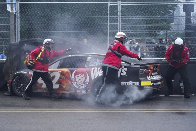Track safety workers assist Noah Gragson after he crashed into a tire barrier during a NASCAR Cup Series auto race at the Grant Park 220, Sunday, July 2, 2023, in Chicago. (Photo by Erin Hooley/AP Photo)