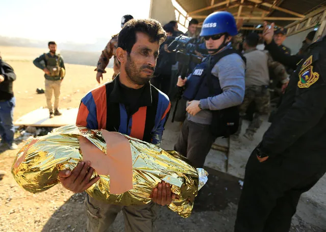 A displaced man carries his daughter who died due to clashes as he flees from Islamic State militants of Tahrir neighborhood, in Mosul, Iraq November 22, 2016. (Photo by Thaier Al-Sudani/Reuters)