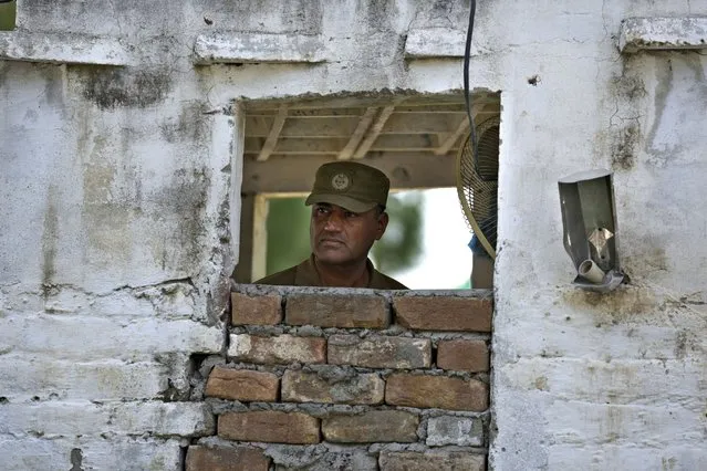 A police officer observes area at a checkpoint on a road leading to the District Jail, in Attock, Pakistan, Wednesday, August 30, 2023. A court asked the official in charge of the Attock prison to keep former Prime Minister Khan there until at least Wednesday, when Khan is expected to face a hearing on charges of “exposing an official secret document” in an incident last year when he waved a confidential diplomatic letter at a rally. The Islamabad High Court on Tuesday suspended the corruption conviction and three-year prison term of him, his lawyers and court officials said. (Photo by Anjum Naveed/AP Photo)