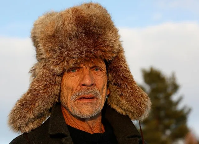 Mikhail Baburin, 66, wearing a Siberian lynx fur hat, is seen in the remote Siberian village of Mikhailovka, Krasnoyarsk region, Russia, December 5, 2016. (Photo by Ilya Naymushin/Reuters)