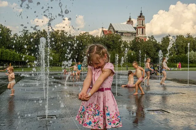 Children cool off in a public fountain in Vilnius on August 20, 2023. The hot weather continues in Lithuania as temperatures rise high to 32 degrees Celsius. (Photo by Yauhen Yerchak/SOPA Images/Rex Features/Shutterstock)