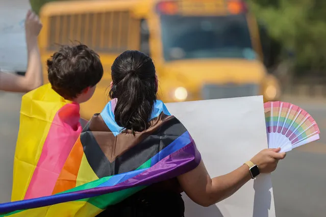 Protesters are seen outside the Katy Independent School District's central office wearing numerous pride and transgender flags, holding signs toward the busy road on August 31, 2023 in Katy, Texas. (Photo by Reginald Mathalone/NurPhoto/Rex Features/Shutterstock)